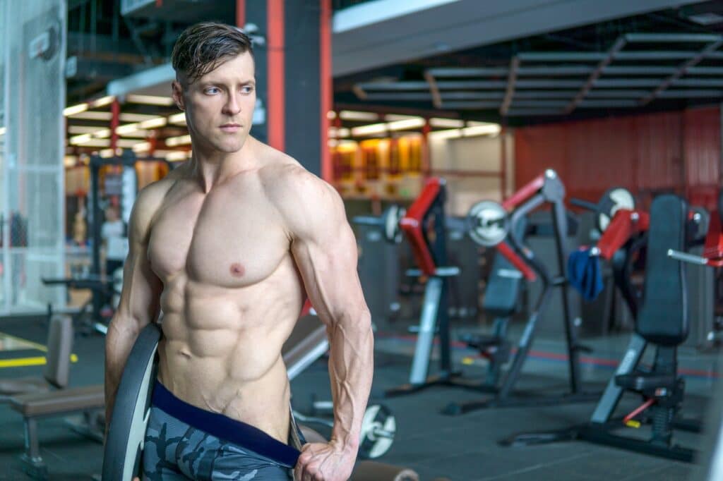 uomo muscoloso completamente depilato in palestra